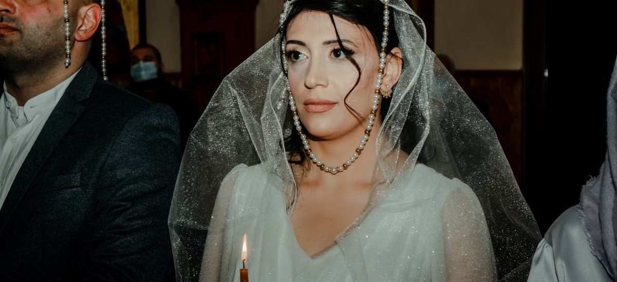 Bride and groom in a traditional wedding ceremony with cultural crowns and attire.