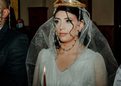 Bride and groom in a traditional wedding ceremony with cultural crowns and attire.