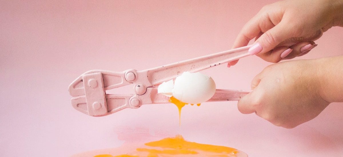person holding white plastic spoon with yellow powder