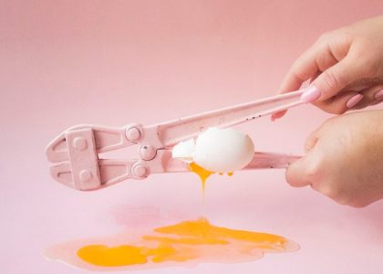 person holding white plastic spoon with yellow powder